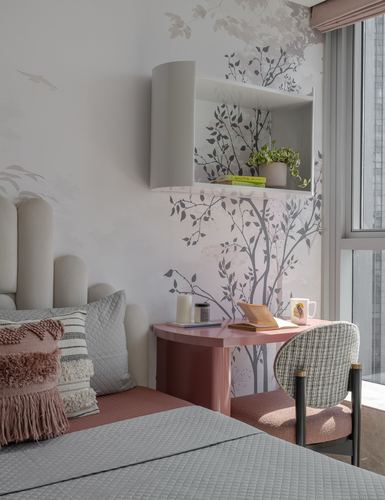 Bedroom corner with tree mural, floating shelf, pink desk and tweed chair by window