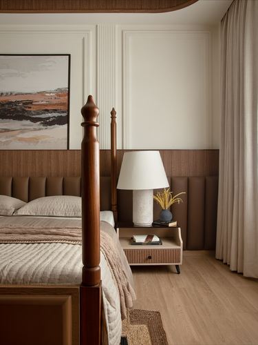 Bedroom corner with carved wood four-poster bed, tufted leather headboard, and landscape art