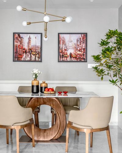 Dining table with circular wood base, marble top, and cityscape art above chairs