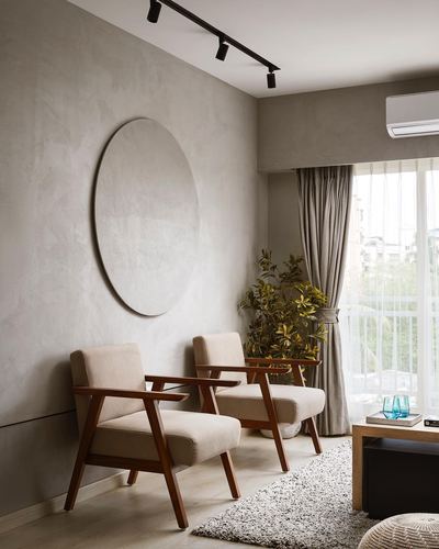 Two wooden armchairs against a textured beige wall with a circular wall niche and curtained window