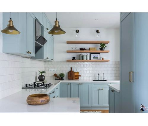 Powder blue kitchen with brass pendant lights, white subway tile, and open wood shelving