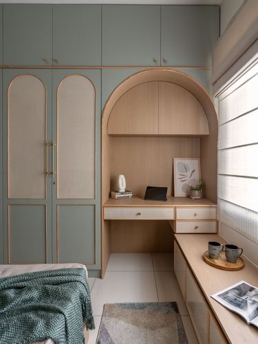 Sage green wardrobe beside an arched wood study nook with desk and window seat