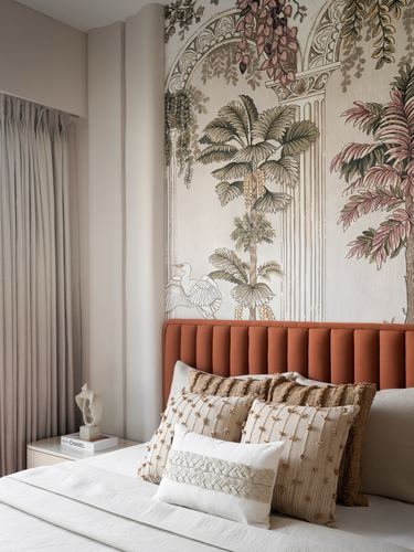 Bedroom with terracotta channel-tufted headboard against botanical mural wallpaper and layered cushions