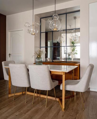 Dining table with marble top and brass legs under bubble glass pendant lights