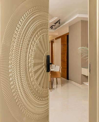 Ornately carved gold door swings open to reveal a warm-toned dining and foyer space beyond