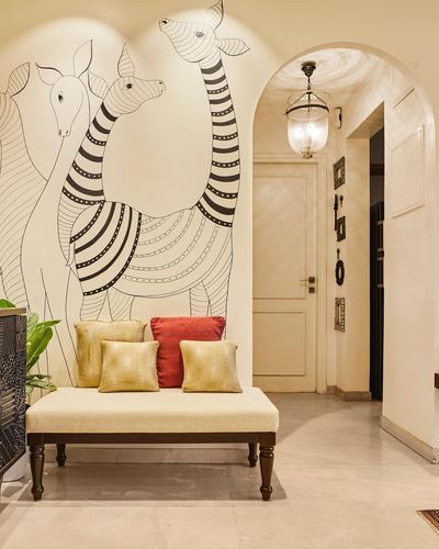 Entryway bench under a black and white folk mural of giraffes, arched doorway beyond