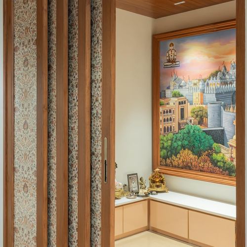 Pooja alcove with folding fabric doors and large painted temple cityscape above cabinetry