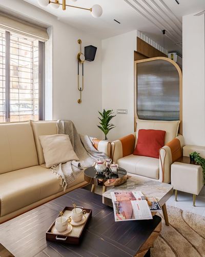 Cream leather sofa and armchairs around dark wood coffee table beside arched glass partition