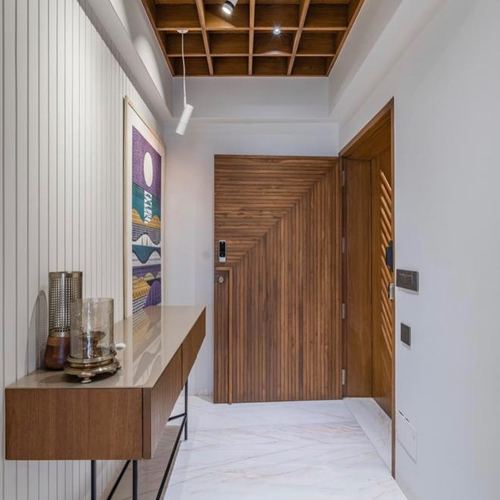 Entrance foyer with chevron wood door, coffered wood ceiling, console table and marble floor