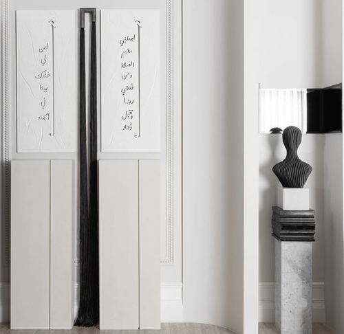 Textured white calligraphy panels beside a black tassel, sculptural bust on marble pedestal