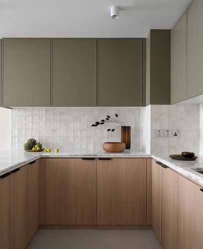 U-shaped kitchen with olive green upper cabinets, wood lower cabinets, and marble countertop