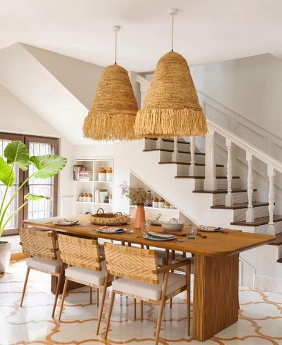 Dining room with fringed rattan pendant lights over a reeded wood table and cane chairs