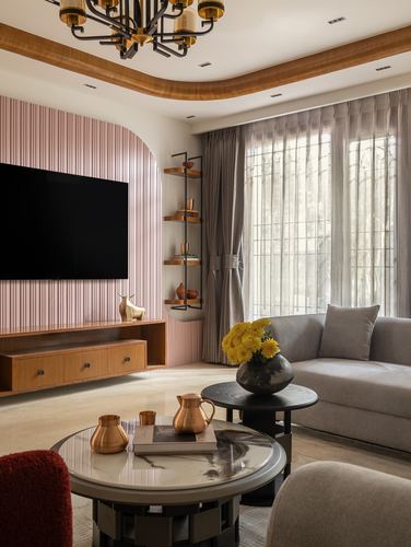 Living room with fluted pink TV wall, wooden console, sheer-curtained window and grey sofa