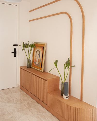 Ribbed wood console below curved wooden wall trim, styled with plants and a portrait painting