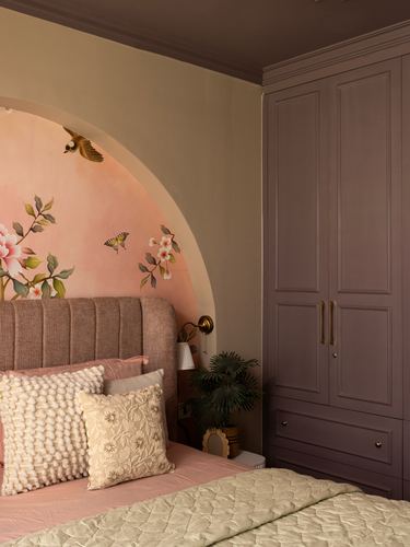 Bedroom with painted floral arch, mauve wardrobe, and channel-tufted pink headboard