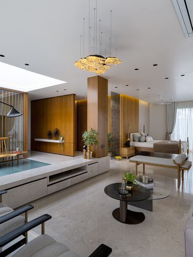 Open bedroom and lounge with wood column, glass table, sculptural chandelier, and marble flooring