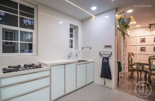 Pastel green kitchen with patterned floor tile, gas cooktop, and glimpse into dining area