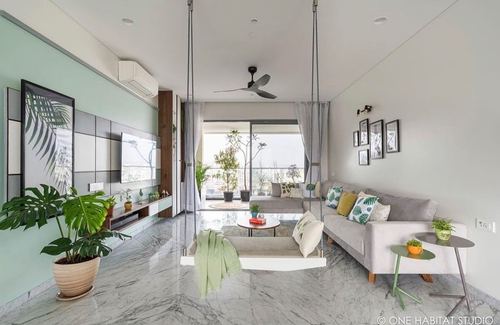 Living room with mint wall, marble floor, gray sofa, hanging swings and balcony view