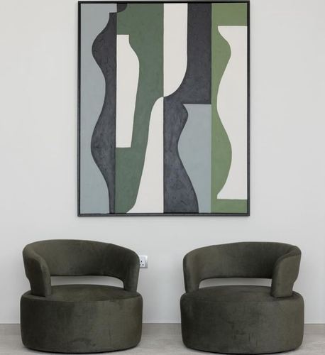 Two olive velvet curved armchairs beneath a large abstract painting on a white wall