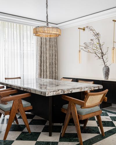 Dining room with marble-top table, cane armchairs, and checkerboard marble floor