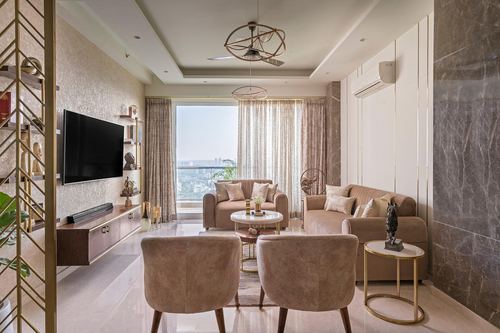 Beige and gold living room with two sofas, armchairs, marble accents and city view window
