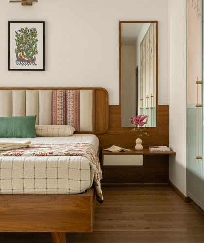 Bedroom with curved wooden headboard, floor mirror, and floating nightstand with flowers