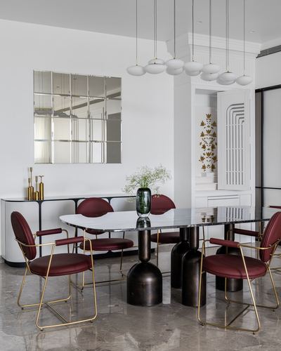 Dining room with marble table, burgundy leather chairs, cylindrical bases, mirror grid on wall