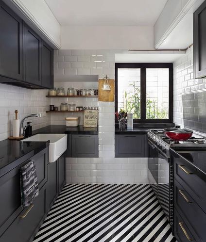 Galley kitchen with charcoal cabinets, white subway tile, and diagonal black-and-white floor pattern