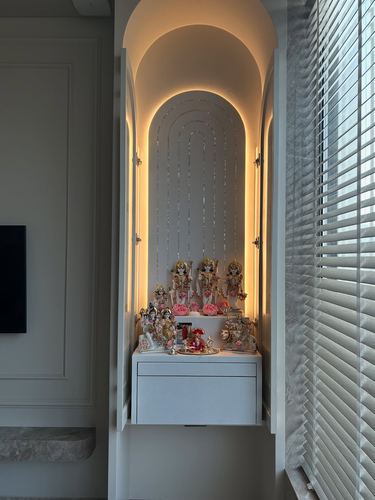 Backlit arched pooja niche with deity idols in a contemporary Mumbai home
