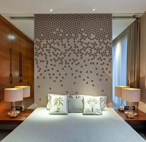 Bedroom with laser-cut patterned headboard panel flanked by mirrored walls and bedside lamps