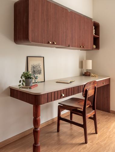 Wall-mounted wood cabinets above a built-in desk with turned leg and wooden chair