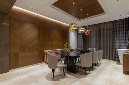Formal dining room with wood-paneled walls, black table, and three round pendant lights