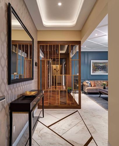 Foyer with mirror and console table opening through brass lattice screen to blue living room