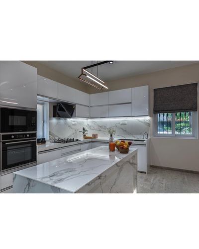White gloss kitchen with marble-look island, backsplash, and linear pendant light