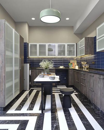 Modern kitchen with striped marble floor, grey wood cabinetry, blue subway tile backsplash, and central island.