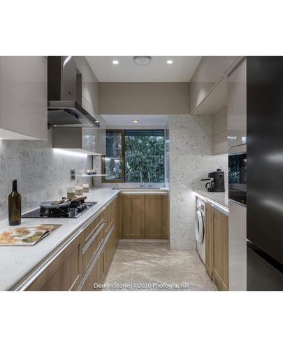 U-shaped kitchen with stone backsplash, wood cabinetry and window above sink