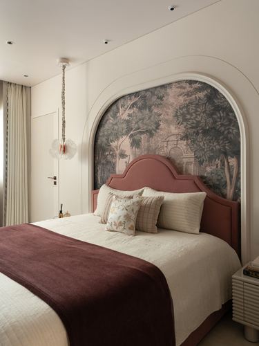 Bedroom with arched mural niche, rose upholstered headboard, and maroon throw on bed