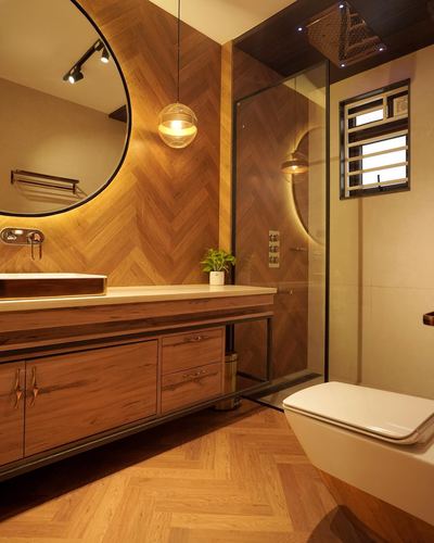 Bathroom with herringbone wood walls, round mirror, floating vanity and glass shower enclosure