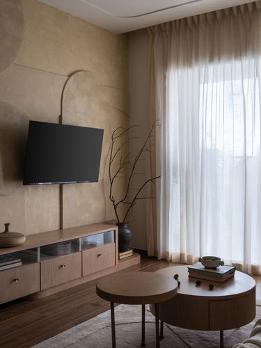Living room with textured plaster wall, mounted TV, wood console and round nesting coffee tables