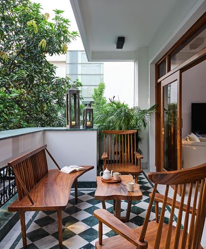 Balcony seating with wood chairs, bench, and tea tray on green-white marble floor