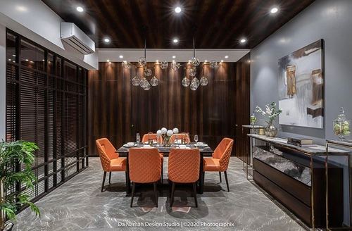 Dining room with orange quilted chairs, dark wood panelling, marble floor and cluster pendant lights