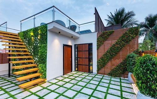 Terrace facade with floating wooden staircase, vertical garden wall, and grid-patterned green flooring