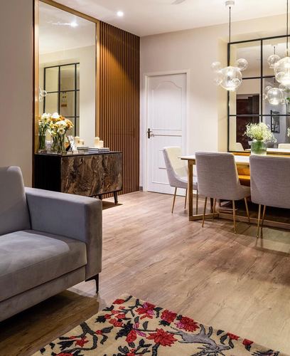 Living and dining space with marble console, fluted wood panel, and bubble chandeliers over dining table
