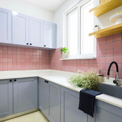 Compact kitchen with periwinkle cabinets, pink square tile backsplash, white counter and open wood shelving