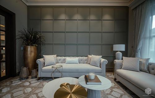Living room with tufted grey sofas, gridded panel wall, and layered round marble coffee tables