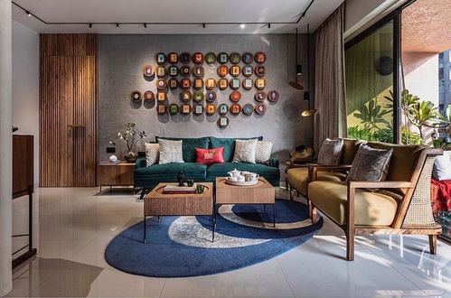 Living room with green velvet sofa, cane-sided armchairs, and a wall installation of round framed artworks on a grey textured wall