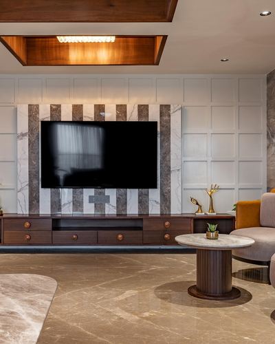 Living room with striped marble TV wall, wooden console, and round marble coffee table