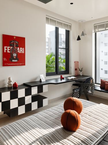 Kid's study nook with Ferrari poster, checkerboard cabinet, window seat, and basketball cushions on striped bed.