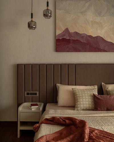 Bedroom with brown channel-tufted headboard, mountain artwork, and terracotta throw