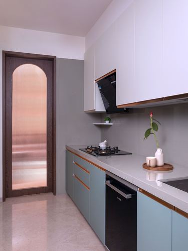 Galley kitchen with sage cabinetry, white counters, and an arched fluted-glass door